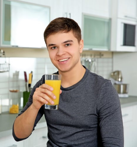 young man drinking juice kitchen 500 komprimiert